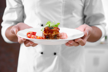 Chef cook holding meat dish, close up