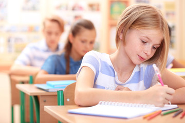 Fototapeta na wymiar Cute schoolgirl in classroom on lesson