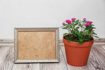 Roses in pot and photo frame on floor