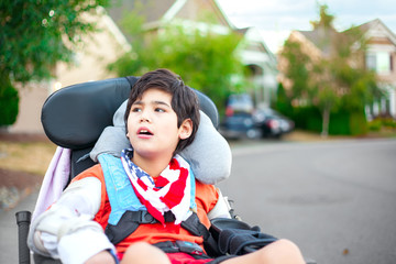 Young disabled boy in wheelchair looking up into sky - Powered by Adobe