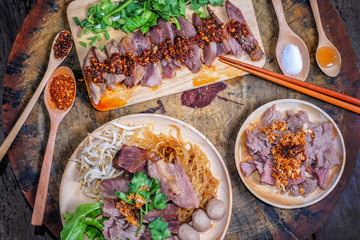 Thai noodle with sliced beef and beef meatballs without soup on big wood cutting board