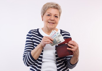 Happy senior female holding wallet with polish currency money, concept of financial security in old...