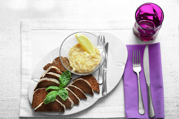 Plate with bread and caviar on wooden table