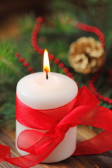 Burning candle on the christmas tree background