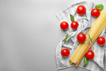 Dry spaghetti pasta with cherry tomatoes on table