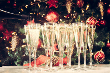 Filling up glasses for party. Glasses of champagne with Christma