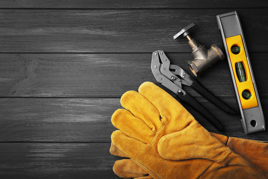 Plumber tools on a gray wooden background