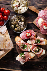 Spanish tapas with slices jamon serrano, salami, olives and chee