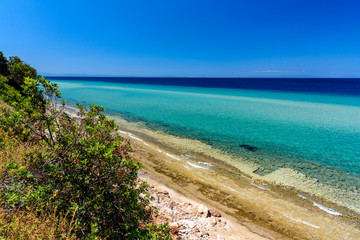 Fototapeta na wymiar Beautiful beach on Thassos island, Greece - turquoise crystal clear waters and soft sand, clear sky - perfect vacation destination
