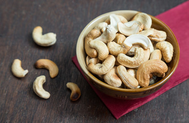 Bowl of cashew nuts from above. On wood background.
