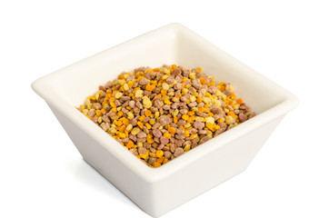 Bee pollen in the bowl closeup isolated on white background