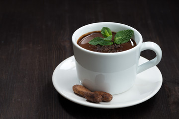 hot chocolate with mint in a cup on a dark wooden background