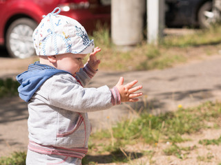 Beautiful baby boy playing on the playground with her mother. The  is dressed in a light bike
