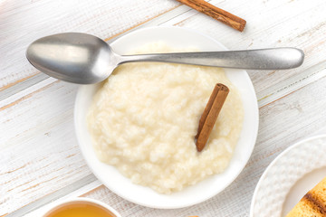 overhead shot pile of rice pudding on porcelain plate, on wood