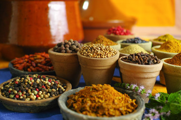 Collection of different spices in old clay bowls in colorful oriental style