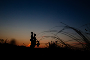 Fototapeta na wymiar silhouette of a happy family with a child in a field
