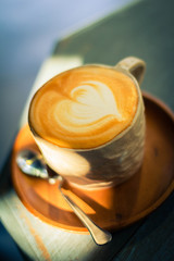 A Cup of hot latte art coffee on wooden table