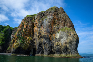 reen rocky cliffs form the coastline of the Avacha Bay, Kamchatka, Russia