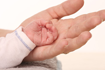 hand of a baby holding the hand of his mother