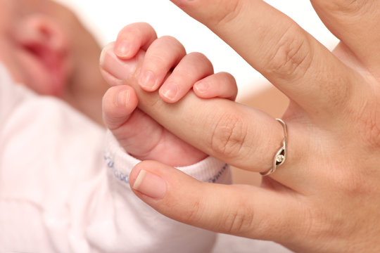 hand of a newborn baby holding her mother hand