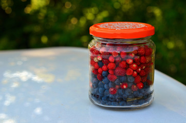 Glass jar of blueberries and strawberries