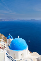 Fototapeta na wymiar traditional blue dome of church with bellfry against blue sea, Oia, Santorini
