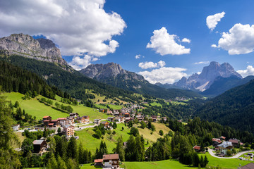 Typical summer scene in Italian Dolomites. Traditional mountain villages with majestic mountains in...