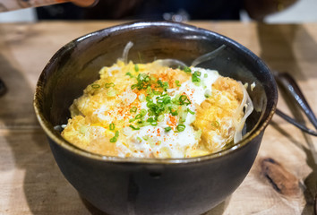 Omelet top pork crispy and rice in bowl black