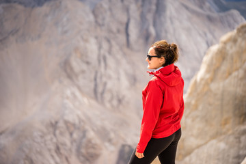 Young female tourist enjoying view of Italian Dolomites. UNESCO World Heritage Site.