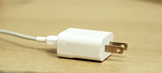 Mobile phone charger cable on wood background © pimonpim