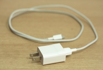 Mobile phone charger cable on wood background