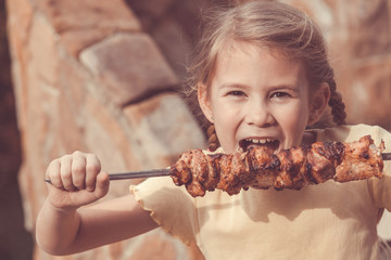 Little beautiful smiling girl with pleasure eats kebab outdoor a © altanaka