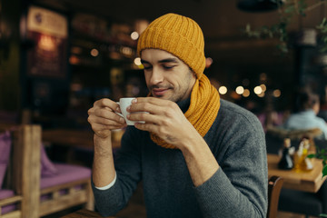 Image of handsome young man enjoying coffee in restaurant