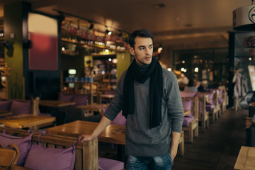 Fototapeta premium Young handsome man standing and posing in the restaurant
