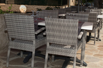 Street view of a coffee terrace with tables and chairs