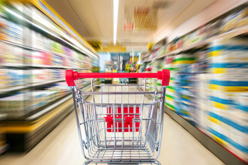 Empty shopping cart in supermarket. Motion blur