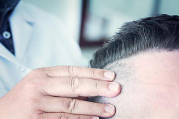 Barber makes a mohawk hairstyle of a man