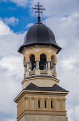 Fototapeta na wymiar Bell tower of Coronation Cathedral deticated to Holy Trinity in Citadel of Alba Iulia city in Romania