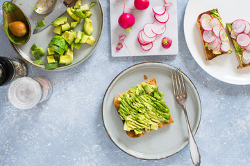 Smashed avocado on whole grain toast to make avocado and radish sandwiches