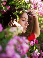 Fototapeta premium Pretty girl among blossoming flowers