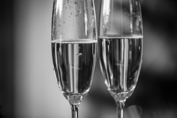 Macro black and white shot of champagne bubbles in two glasses