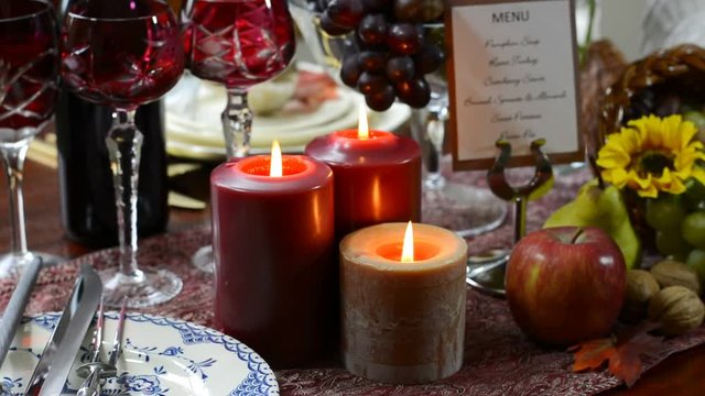 Colorful rustic style Thanksgiving table with closeup on burning candles.