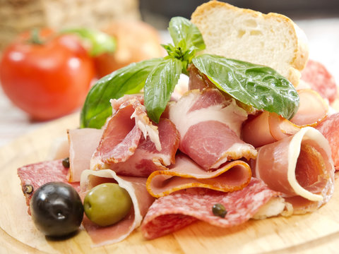 Food tray with delicious salami, ham, fresh sausages and herbs. Meat platter with selection.