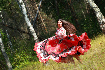 Gypsy girl in national dress dancing in the forest - obrazy, fototapety, plakaty