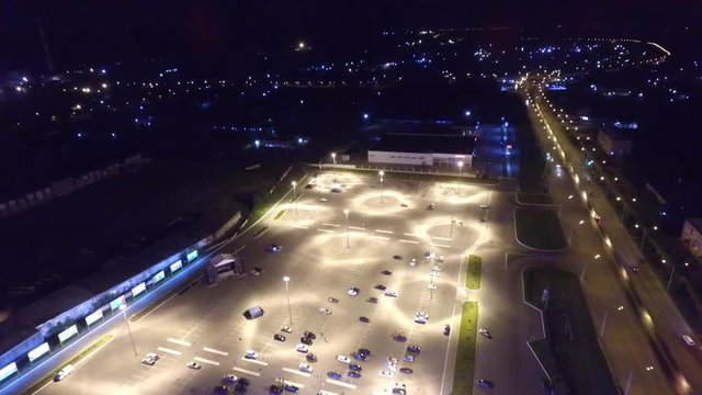 flying above a transport interchange at night. On the road going cars and burning lights.