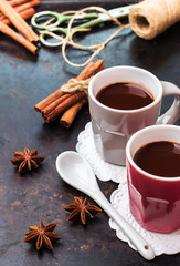 Hot chocolate in mug with spices on grunge dark table