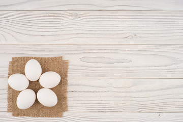 Chicken eggs on white old wooden table.