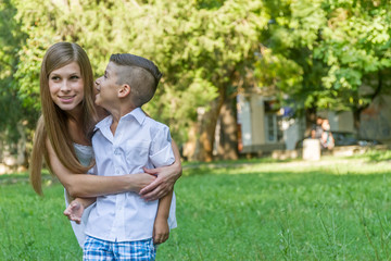 outdoor portrait of young handsome child boy with his mother