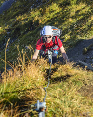 Jugendlicher beim Klettern im Klettersteig