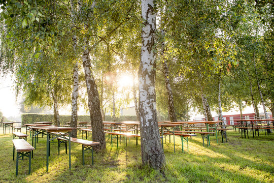 Biergarten im Sonnenschein unter B&auml;umen 